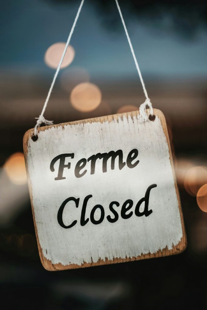 a sign that says ferme closed hanging from a string