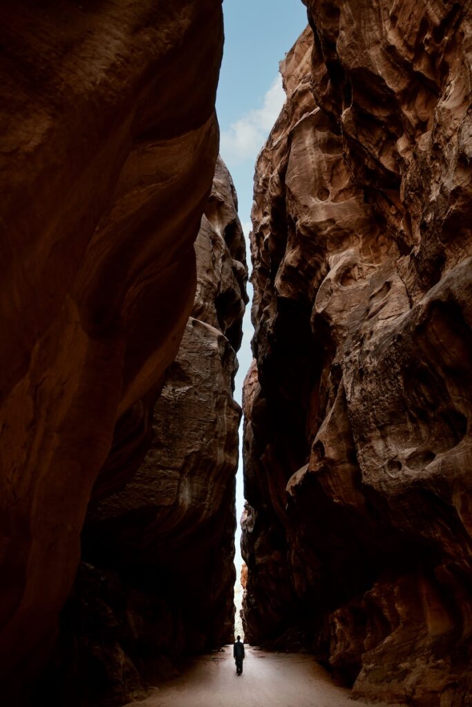 a person walking through a narrow slot in a canyon: comment trouver l'Amour
