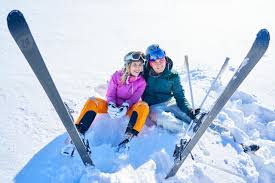 couple au ski assis dans la neige